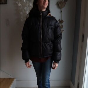 Black puffer jacket with animal print lining and a hood
